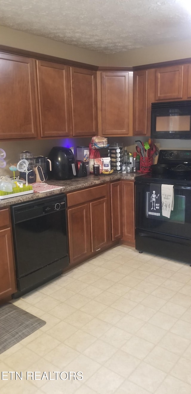 kitchen featuring a textured ceiling and black appliances