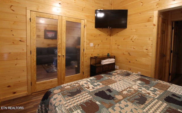 bedroom with wood walls, dark hardwood / wood-style flooring, and a closet