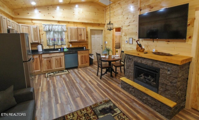 kitchen with wooden walls, hanging light fixtures, dark hardwood / wood-style floors, and appliances with stainless steel finishes