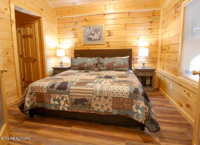 bedroom featuring hardwood / wood-style flooring and wood walls