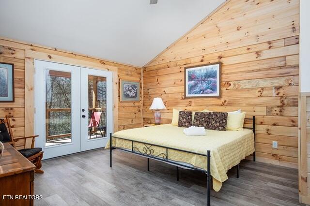 bedroom with access to exterior, wood walls, french doors, and wood-type flooring