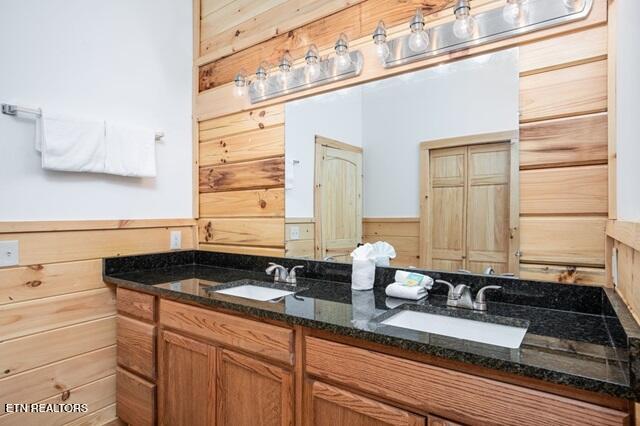 bathroom with wood walls and vanity