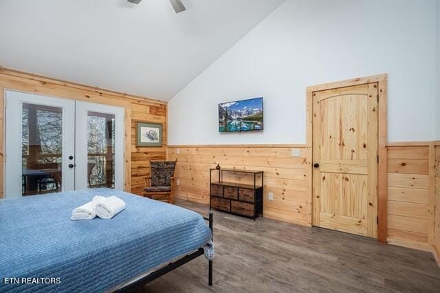 bedroom featuring ceiling fan, french doors, dark wood-type flooring, and wood walls