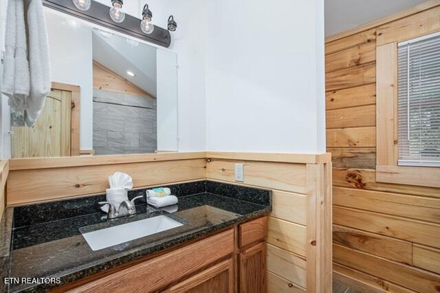 bathroom with vanity and wooden walls