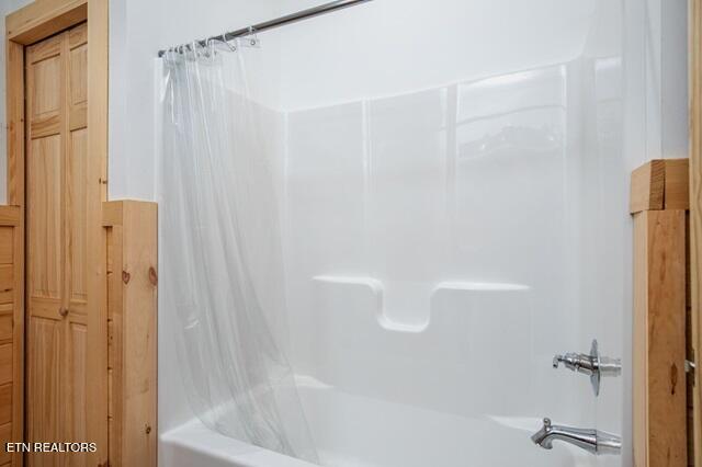 bathroom with shower / bathtub combination with curtain