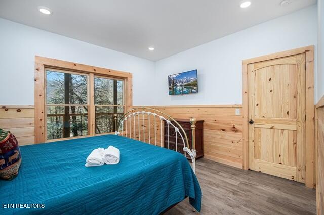 bedroom featuring wooden walls and hardwood / wood-style floors