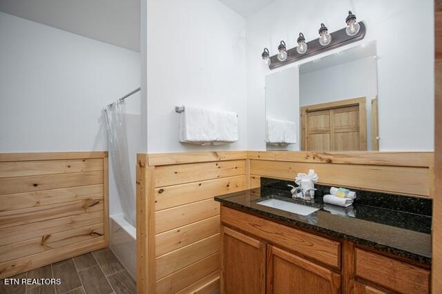 bathroom featuring hardwood / wood-style flooring, vanity, and shower / bath combo