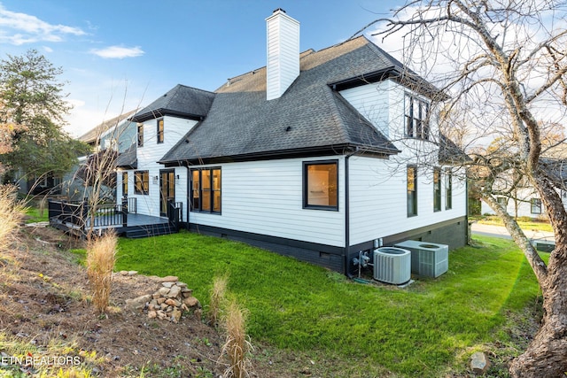 back of property featuring a yard, a deck, and central air condition unit