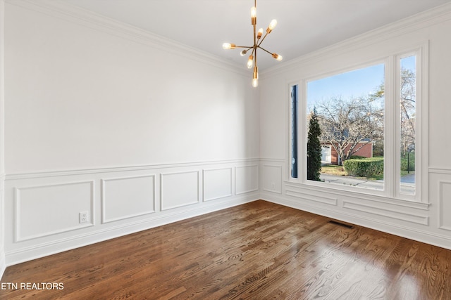 unfurnished room with ornamental molding, a healthy amount of sunlight, a notable chandelier, and wood-type flooring