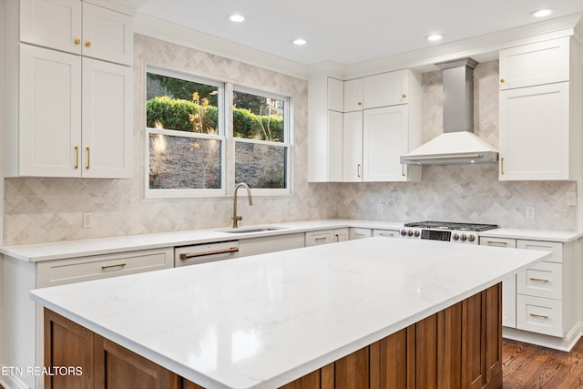 kitchen with white cabinets, crown molding, sink, and wall chimney exhaust hood