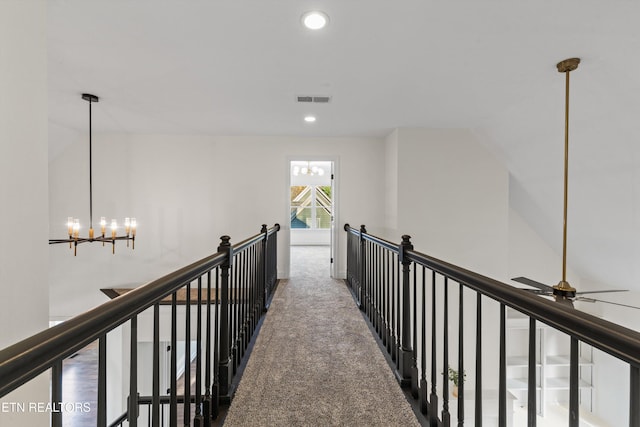 hallway featuring carpet flooring and a chandelier