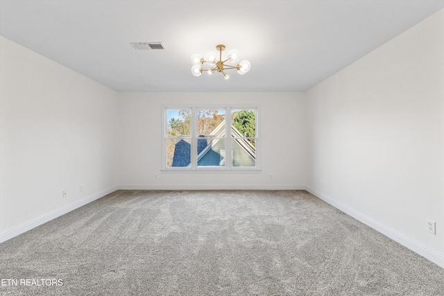 carpeted empty room featuring a chandelier