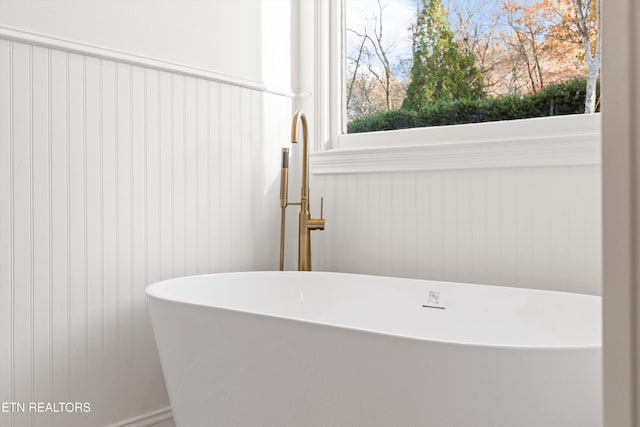 bathroom featuring a washtub and a wealth of natural light