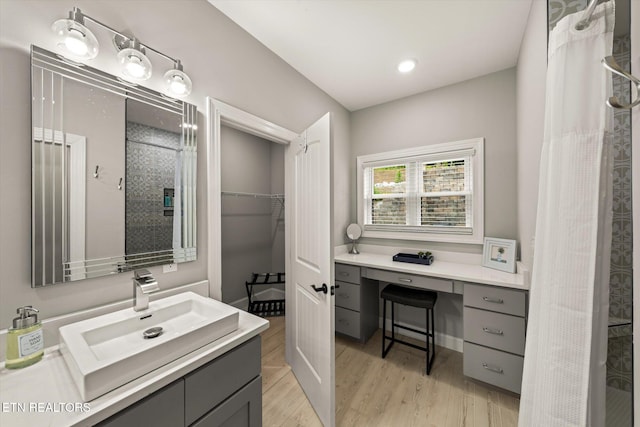 bathroom with hardwood / wood-style floors, curtained shower, and vanity