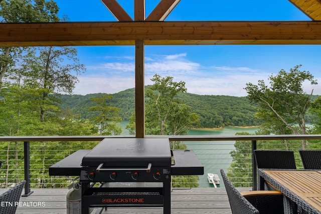 wooden deck featuring grilling area and a water view