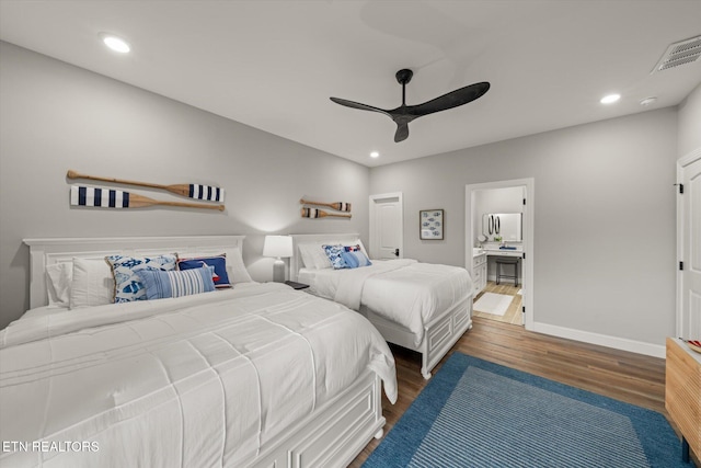 bedroom featuring dark hardwood / wood-style flooring, ceiling fan, and connected bathroom