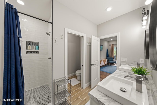 bathroom with hardwood / wood-style floors, vanity, toilet, and a shower with curtain