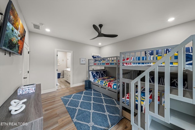 bedroom with hardwood / wood-style flooring, ceiling fan, and ensuite bath