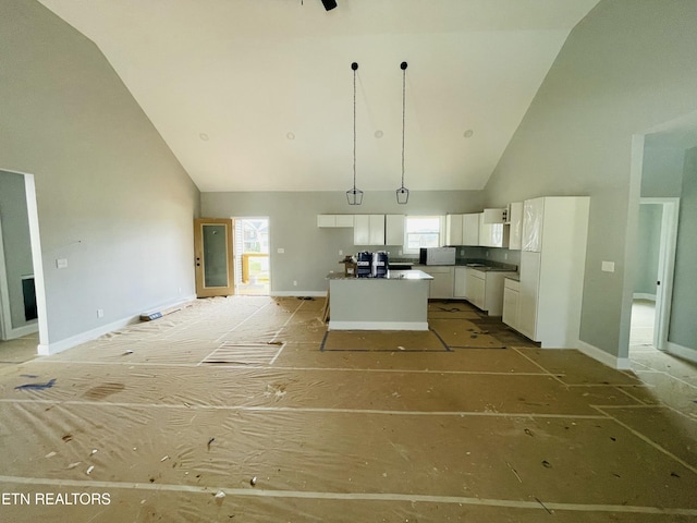 kitchen featuring high vaulted ceiling, a kitchen island, white cabinets, open floor plan, and dark countertops