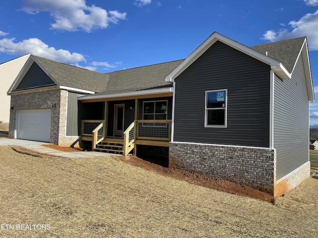 ranch-style house with a porch, a shingled roof, and an attached garage