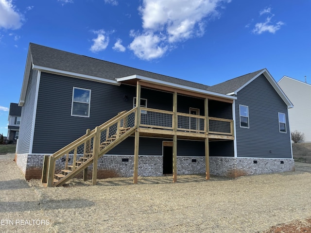 back of property featuring roof with shingles, crawl space, and stairway