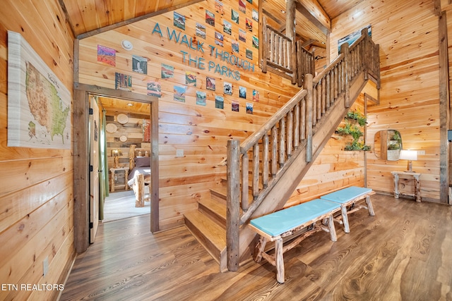 stairway featuring hardwood / wood-style floors, wood ceiling, lofted ceiling, and wood walls