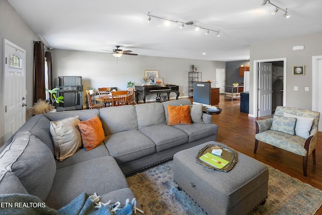 living room featuring rail lighting, dark hardwood / wood-style floors, and ceiling fan