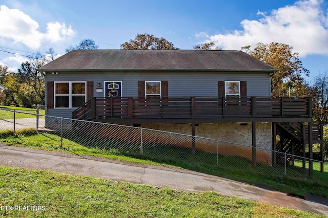 view of front of home featuring a front yard and a wooden deck