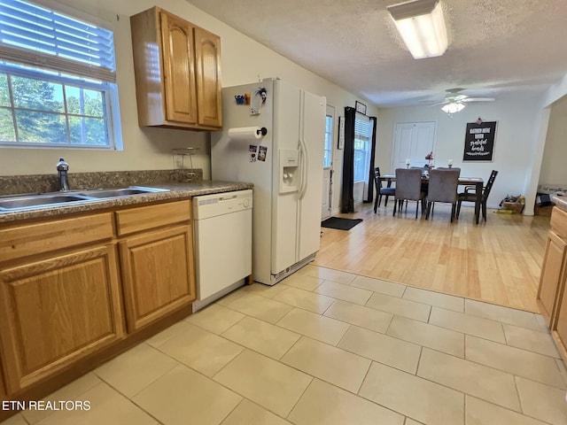 kitchen featuring white appliances, sink, ceiling fan, a textured ceiling, and light hardwood / wood-style floors