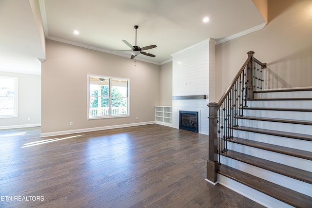 unfurnished living room with dark hardwood / wood-style floors, ceiling fan, ornamental molding, and a fireplace