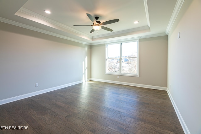 spare room featuring a raised ceiling, crown molding, ceiling fan, and dark wood-type flooring