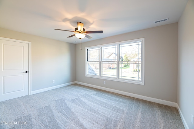 carpeted spare room with ceiling fan