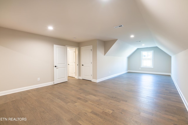 bonus room with dark hardwood / wood-style floors and lofted ceiling