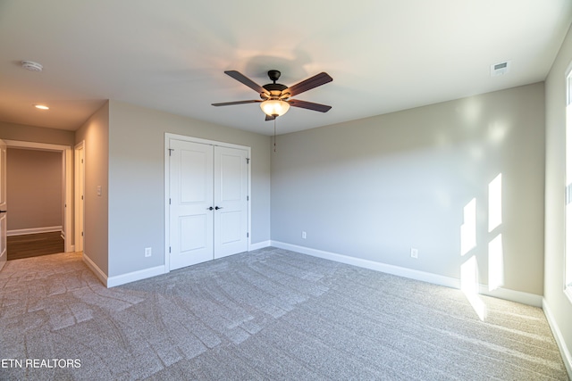 unfurnished bedroom with ceiling fan, a closet, and carpet