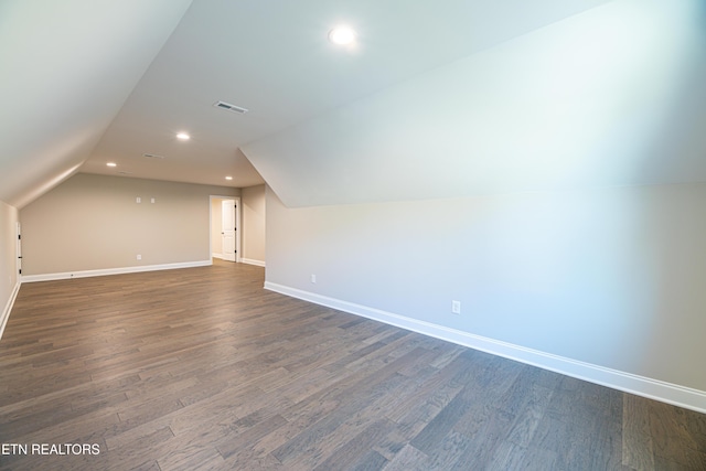 additional living space featuring dark hardwood / wood-style flooring and vaulted ceiling