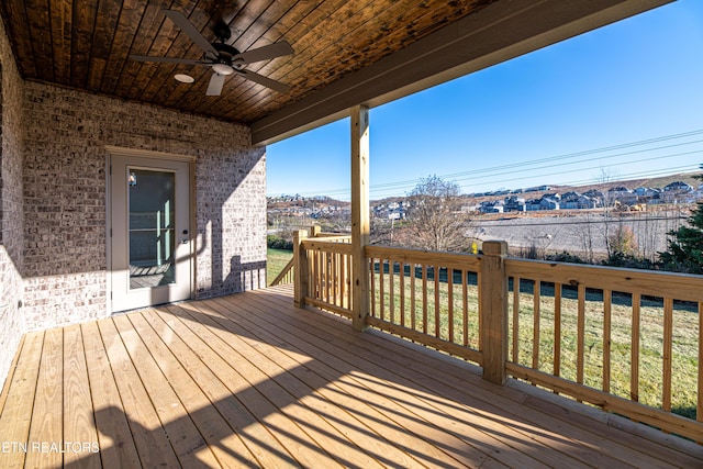 wooden deck with ceiling fan and a lawn