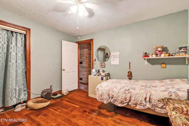 bedroom featuring a textured ceiling, ceiling fan, and dark hardwood / wood-style floors