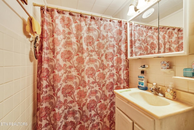 bathroom with vanity, decorative backsplash, and tile walls