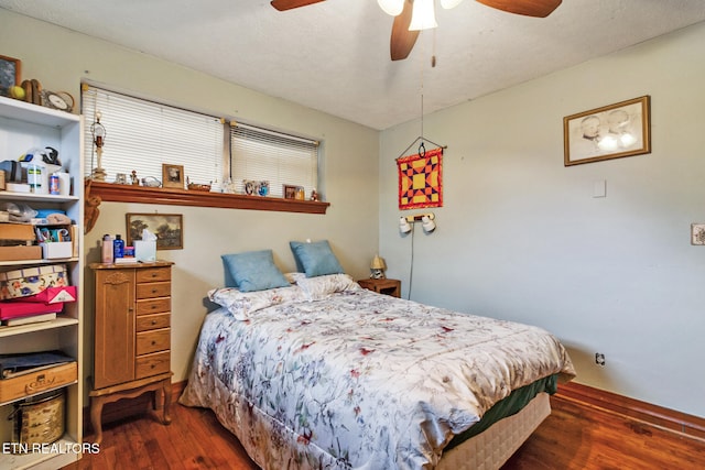 bedroom featuring ceiling fan, dark hardwood / wood-style floors, and a textured ceiling