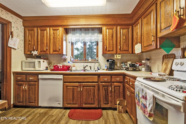 kitchen with decorative backsplash, white appliances, dark hardwood / wood-style floors, and sink