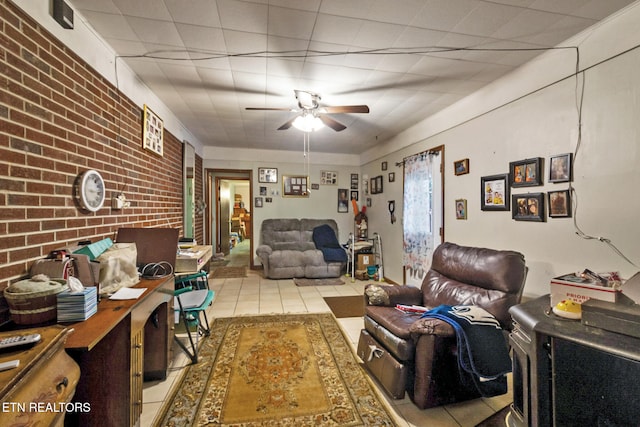 tiled living room featuring ceiling fan and brick wall