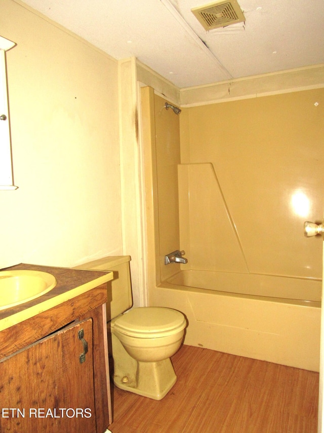 full bathroom featuring vanity, hardwood / wood-style floors, toilet, and shower / tub combination