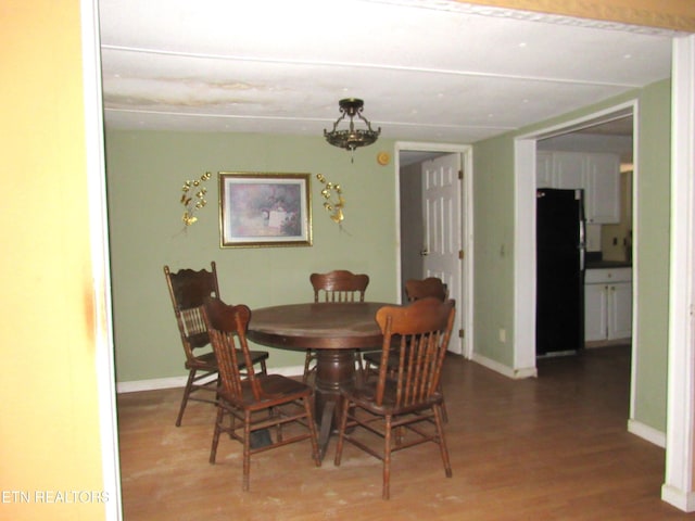 dining area featuring hardwood / wood-style floors and an inviting chandelier