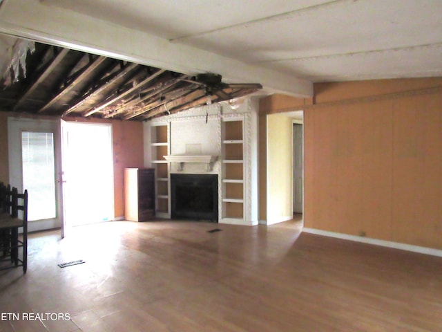 unfurnished living room featuring hardwood / wood-style floors and lofted ceiling