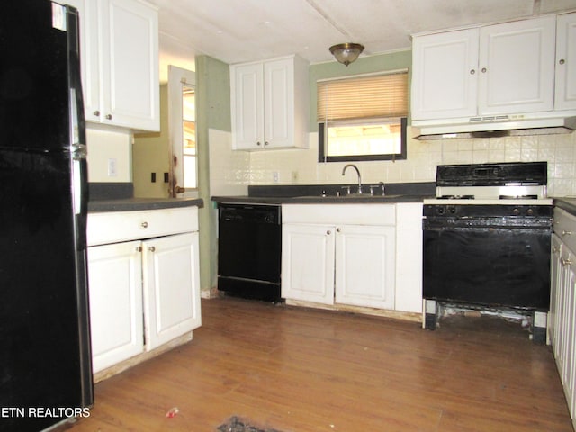 kitchen with black appliances, range hood, white cabinetry, and dark hardwood / wood-style flooring