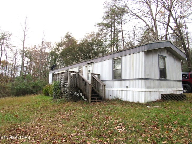 view of front of property featuring a front lawn and a wooden deck