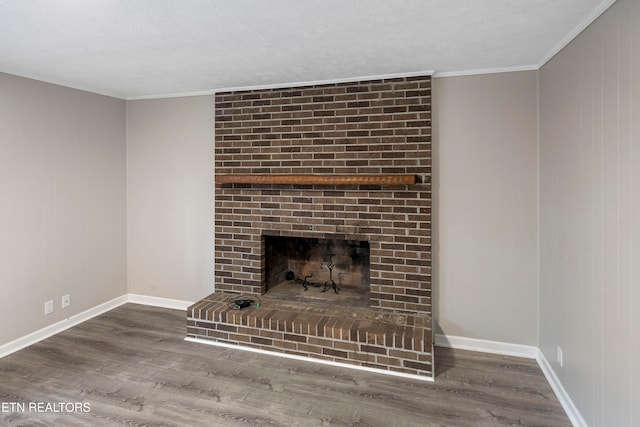 room details with hardwood / wood-style floors, ornamental molding, a fireplace, and a textured ceiling