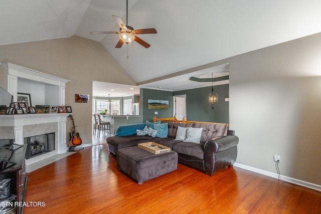 living room featuring ceiling fan, vaulted ceiling, and hardwood / wood-style flooring