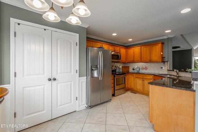 kitchen featuring pendant lighting, decorative backsplash, sink, stainless steel appliances, and light tile patterned floors