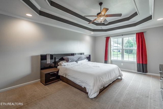 carpeted bedroom featuring ceiling fan, crown molding, and a raised ceiling